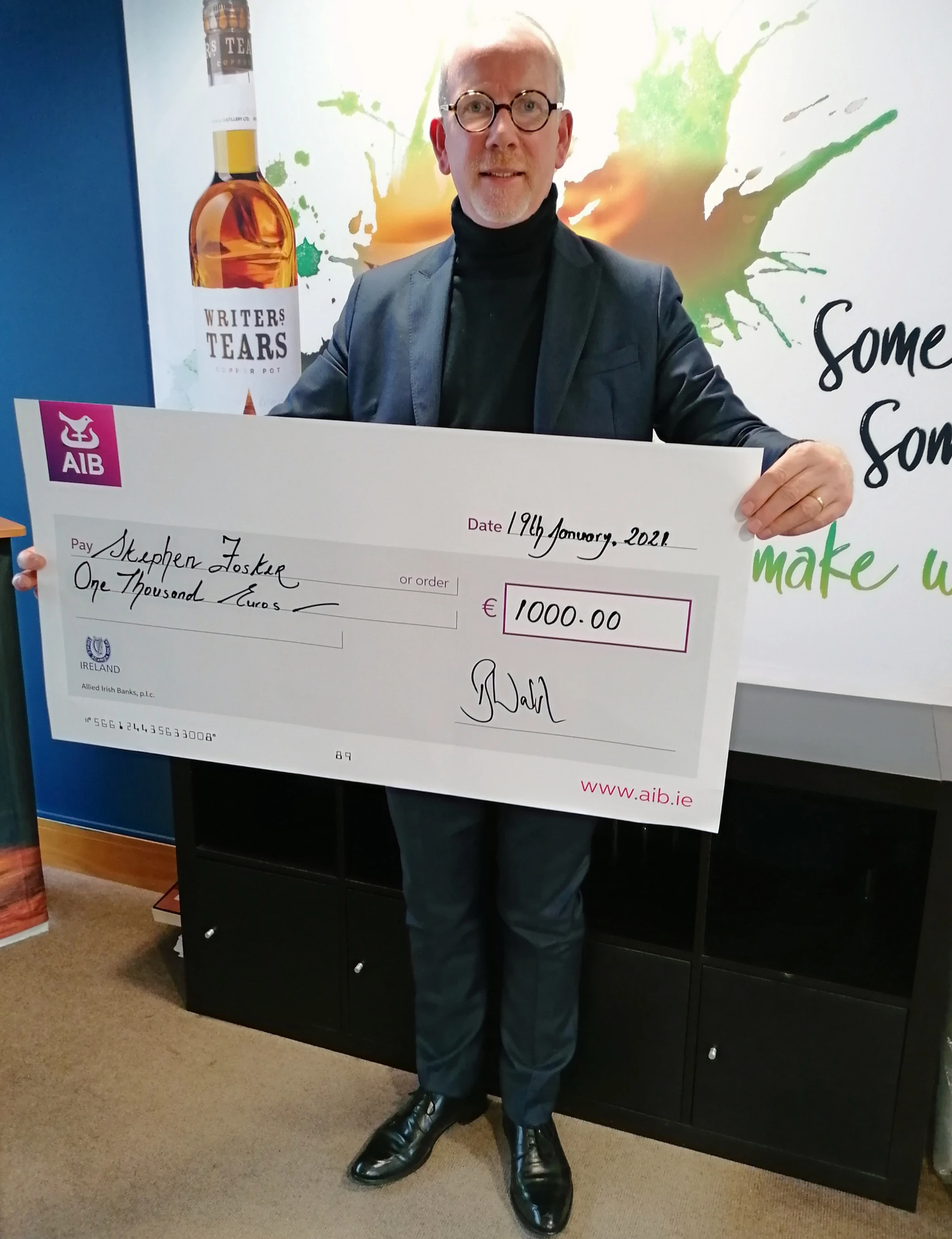 Person holding large cheque